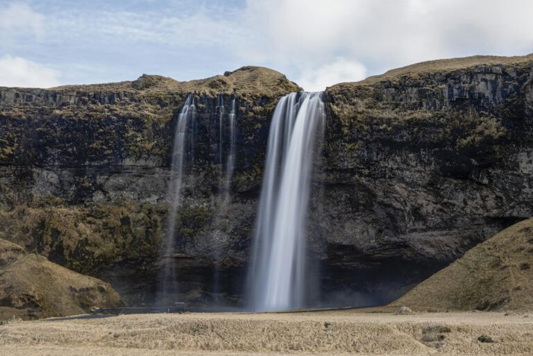 Breathtaking view of Seljalandsfoss waterfall cascading from cliffs in Iceland.
