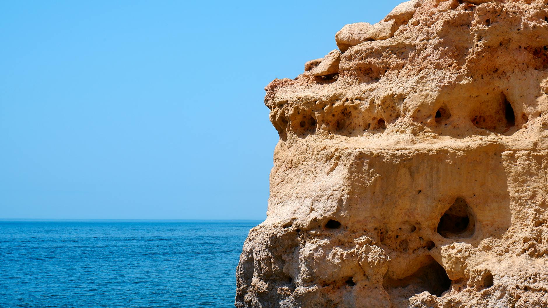 A breathtaking view of limestone cliffs against the azure Atlantic Ocean in Algarve, Portugal. (Photo: Nils Rotura / Pexels)