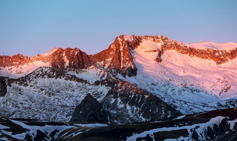 Breathtaking view of the snow-capped Pyrenees during sunset in Benasque, Spain.